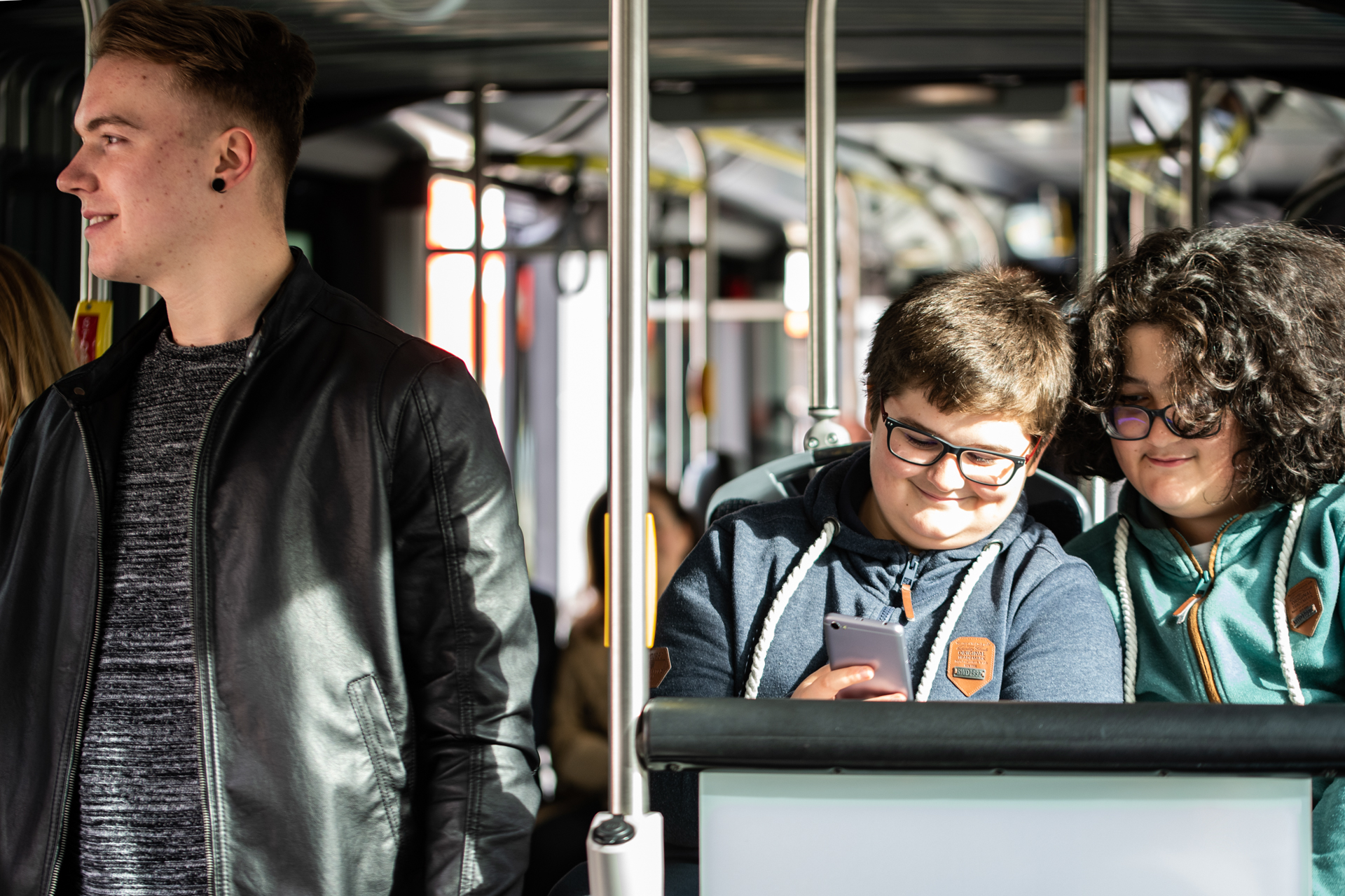 Two young people are checking the phone on the bus.